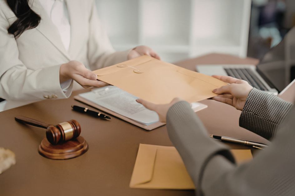 Attorney reviewing documents with a client across a desk with a gavel
